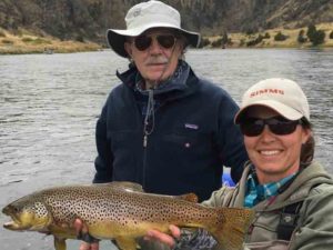 Showing off a trout caught on the Madison River while fly fishing with Nelson's Guides and Flies.